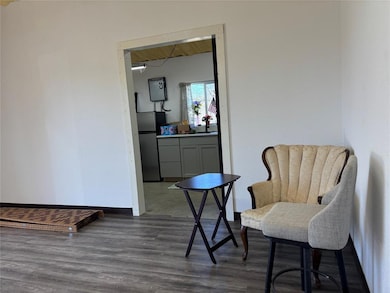 Sitting room with dark wood-style flooring and ba