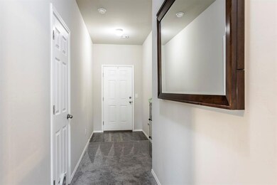 Corridor with dark colored carpet and baseboards