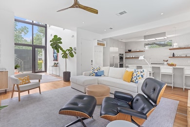 Living room with a ceiling fan, light wood-style 