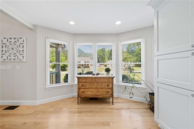 Living area with baseboards, light wood-style floo