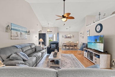Living area with baseboards, high vaulted ceiling,