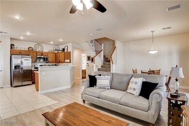 Living room with a ceiling fan, stairs, light wood