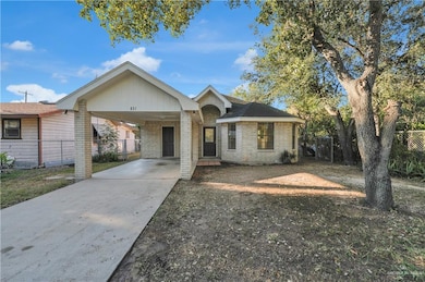 Ranch-style home with concrete driveway, brick siding, and an attached carport