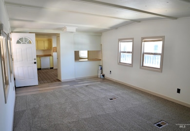 Empty room featuring light colored carpet and light wood-style floors