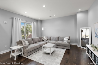 Living room with recessed lighting and dark wood-style floors