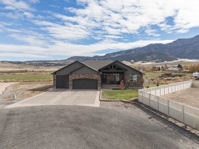 View of front of property with concrete driveway, a mountain view, and a garage