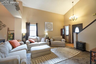 Living room with high vaulted ceiling, a wood stov
