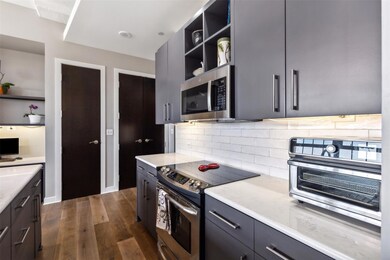 Kitchen with gray cabinets, dark wood-type floorin