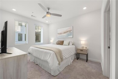 Carpeted bedroom featuring ceiling fan