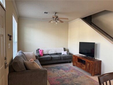 Living room featuring ceiling fan, crown molding,