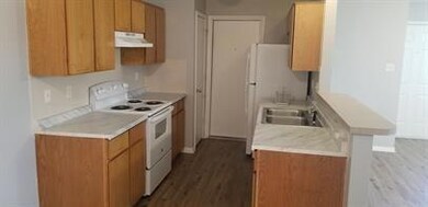 Kitchen featuring light countertops, dark wood-st