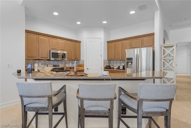 Kitchen with stainless steel appliances, a breakfa