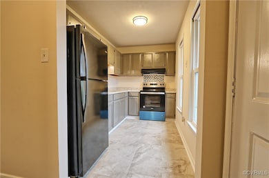 Kitchen with gray cabinets, a textured ceiling, extractor fan, black refrigerator, and stainless steel range