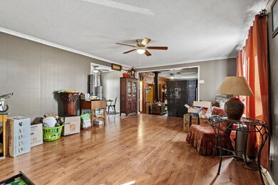 Living area with wood floors, ornamental molding, new ceiling fan with light fixture