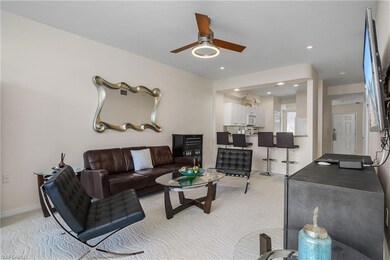 Living room with ceiling fan and light carpet