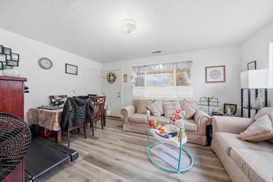 Living area with wood finished floors and a textured ceiling
