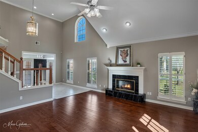 Unfurnished living room featuring ornamental molding, wood finished floors, a high end fireplace, stairway, and a towering ceiling