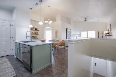 Kitchen featuring a peninsula, hanging light fixtures, arched walkways, dishwasher, and a ceiling fan