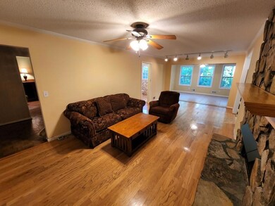 Family Room with Stone Fireplace and View to Sunroom.