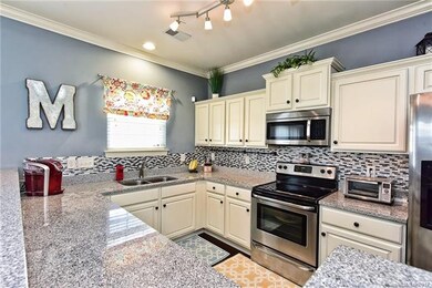 Kitchen has granite counters, hardwood floors and 