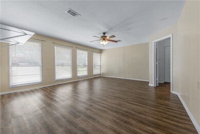 Empty room featuring dark wood-style floors and ce