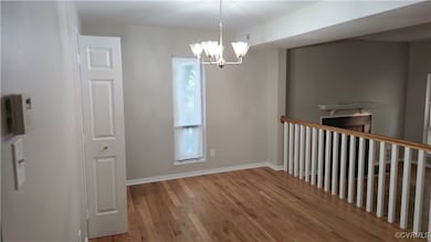 Empty room featuring wood finished floors, a chand