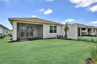Back of home with landscaped area