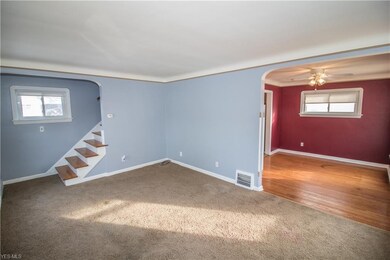 Living Room with Stylish Arched Entryways Leading Upstairs and to the Dining Room