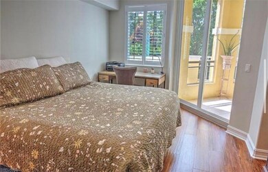 Bedroom with dark wood-style floors and access to exterior
