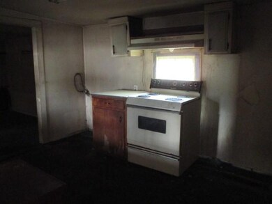 Kitchen featuring electric range, light countertops, and brown cabinets