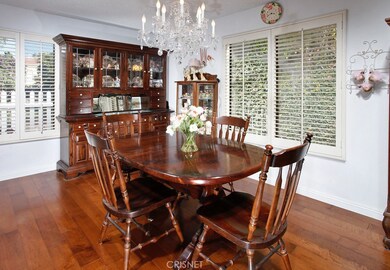 The formal dining room with its picture windows, plantation shutters, shimmering chandelier and gleaming hardwood floors is perfect for any occasion.