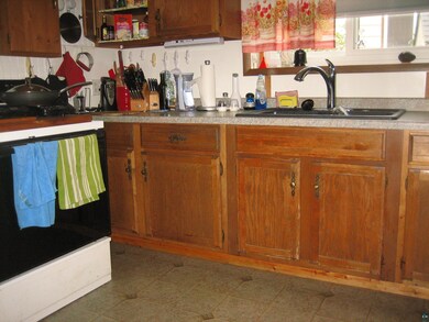Kitchen featuring range, sink, and dark tile patte