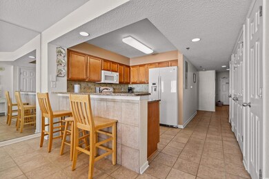 Kitchen featuring a peninsula, white appliances, a