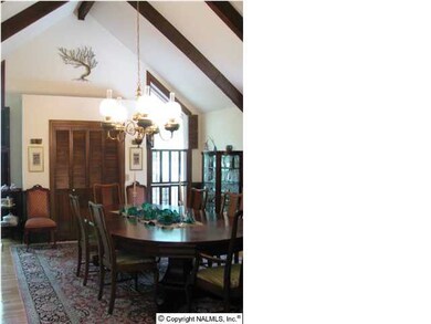 Dining room with chairrail, in-laid oak floors and vaulted ceilings. This room also has 3 stained glass windows by Lumpkin.