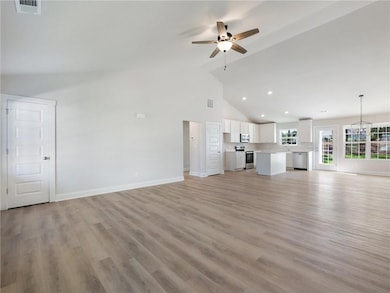 Unfurnished living room with ceiling fan, light ha