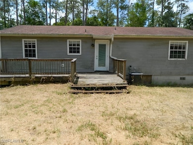 Back of house with a wooden deck, crawl space, a y
