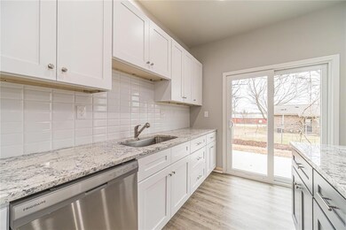 Kitchen countertops are White Ice granite with a subway tile backsplash.