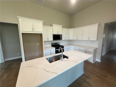 Kitchen featuring range with gas cooktop, white cabinetry, backsplash, and dark wood finished floors