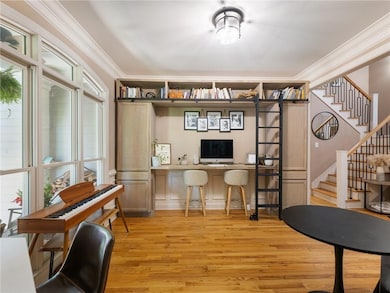 Office with light wood-style floors and crown molding