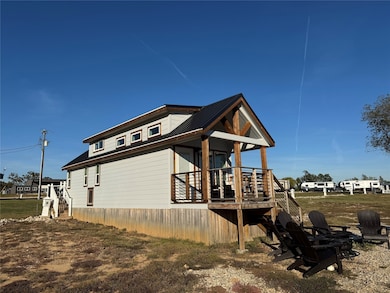 View of side of property featuring an outdoor fire pit and a metal roof