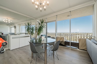 Dining room with a chandelier, healthy amount of natural light, light wood-style flooring, and floor to ceiling windows