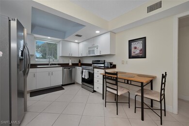 Kitchen featuring appliances with stainless steel finishes, a sink, dark countertops, white cabinets, and recessed lighting