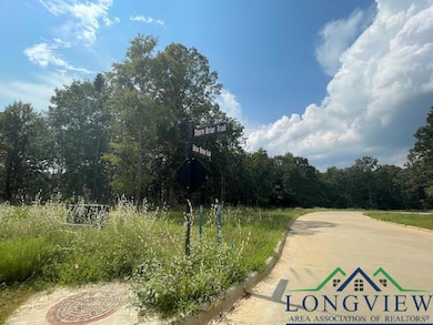 View of concrete street with a wooded view and curbs