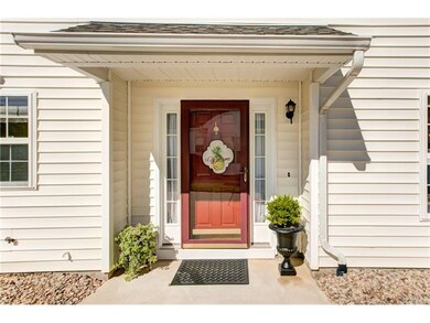 The covered entrance and oversized driveway make a