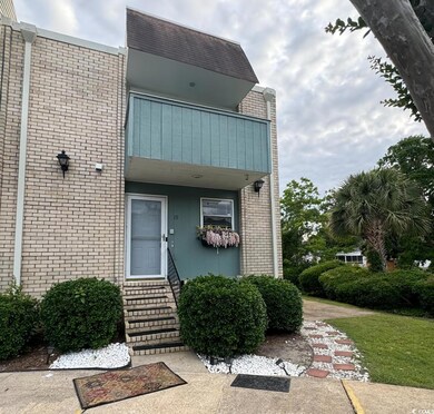Property entrance with a balcony and brick siding