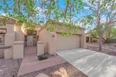 Pueblo-style house with fence, concrete driveway,