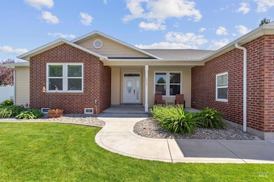 Ranch-style home with brick siding, a front lawn, and covered porch