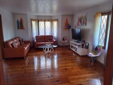 Living room with dark hardwood / wood-style floors and a healthy amount of sunlight
