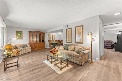 Living room featuring a textured ceiling and light wood-style flooring