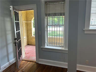 Doorway featuring wood-type flooring and baseboards